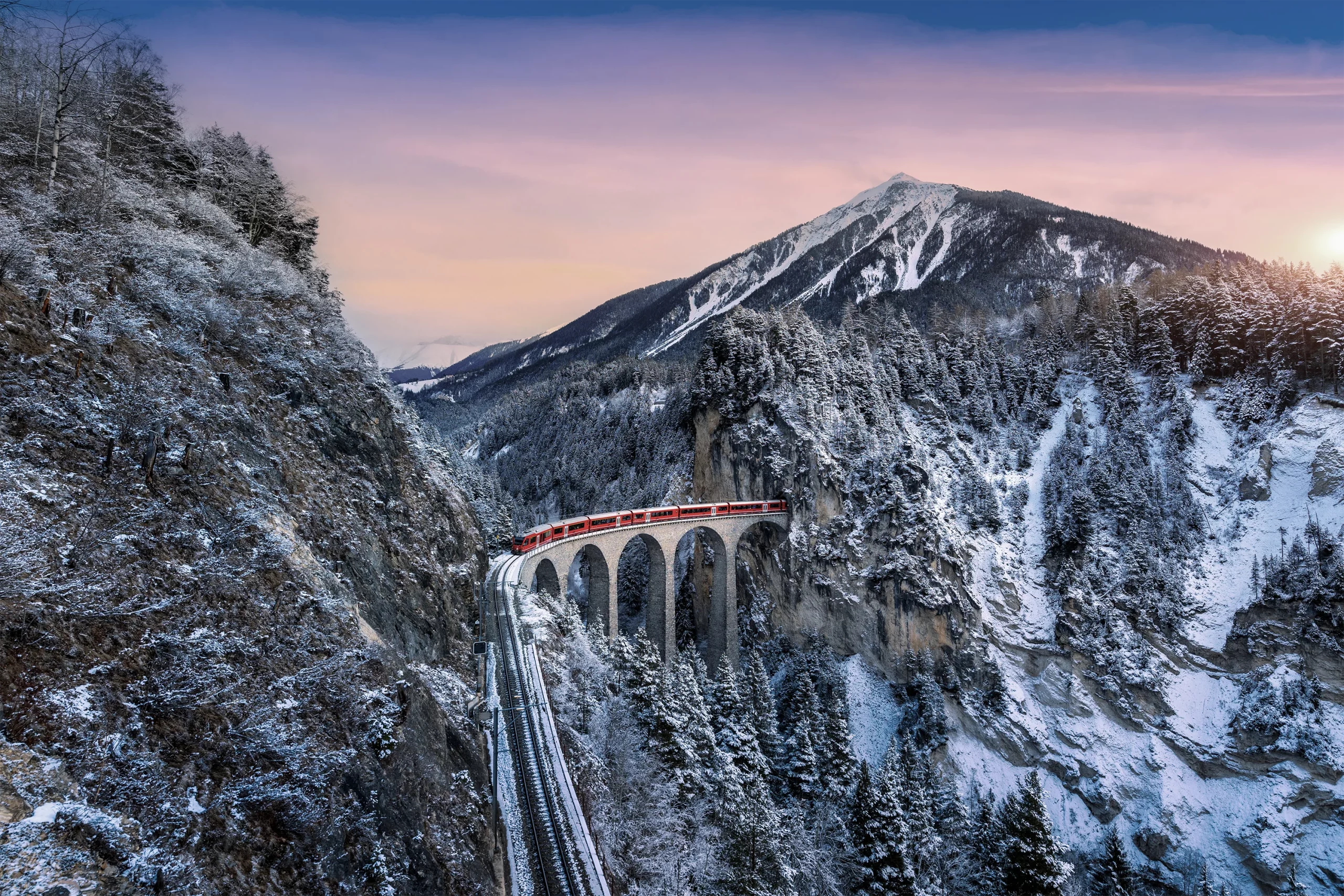 Un train passe entre deux montagnes suisses.