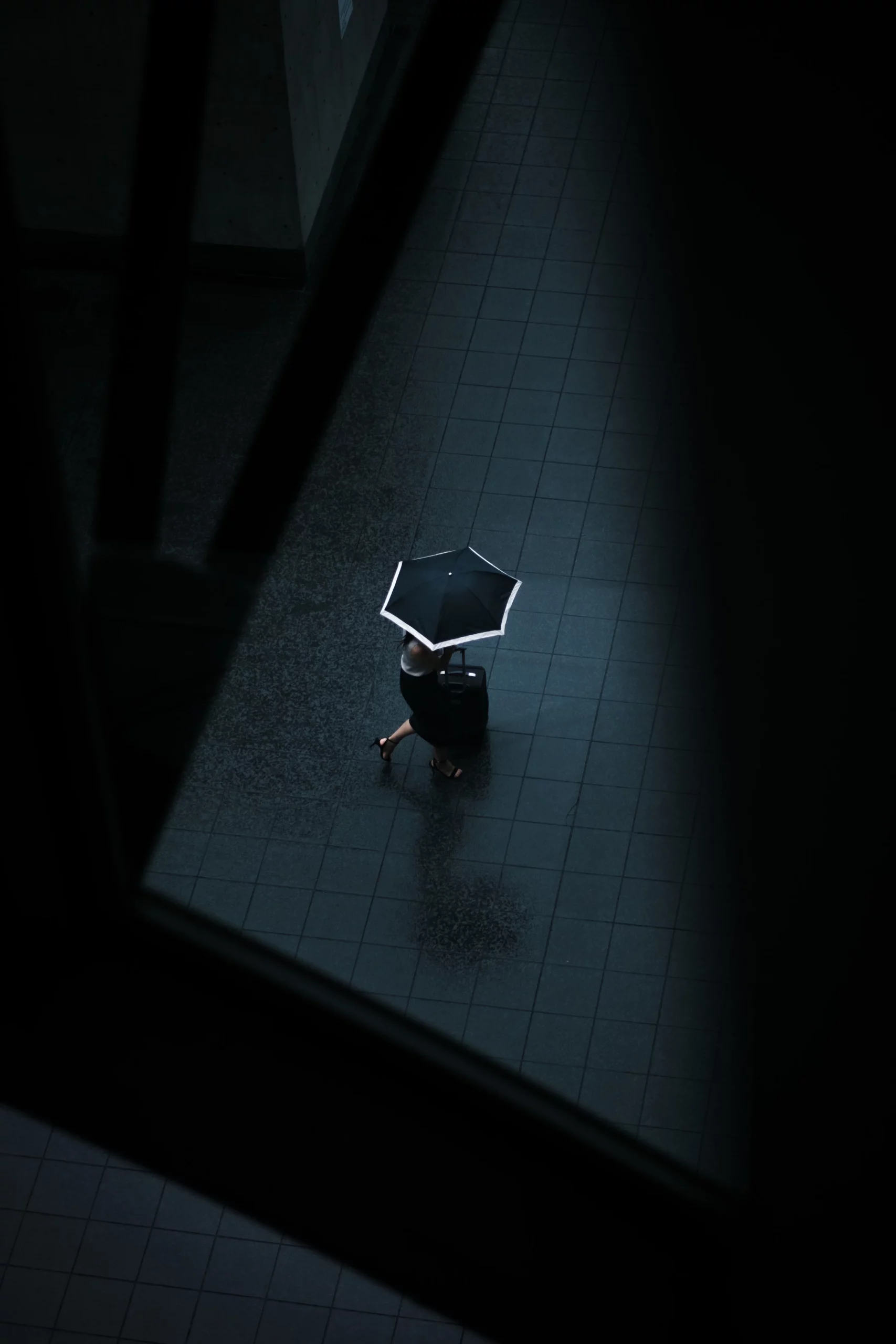 Une femme marche dans la rue avec un parapluie.