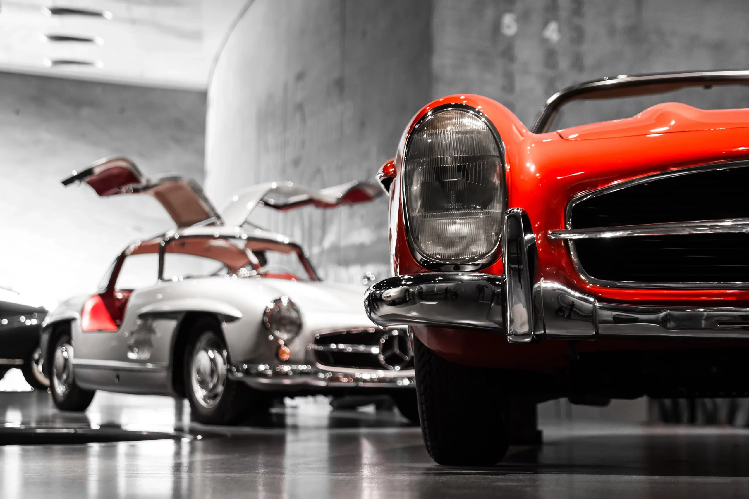 Classic cars on display in a garage.