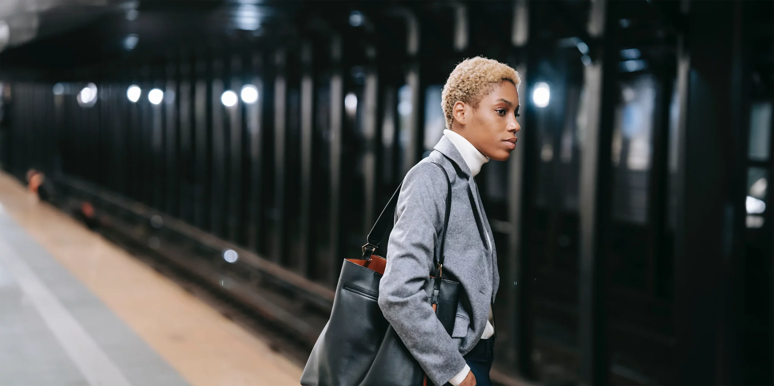 Une femme attend dans une station de métro.