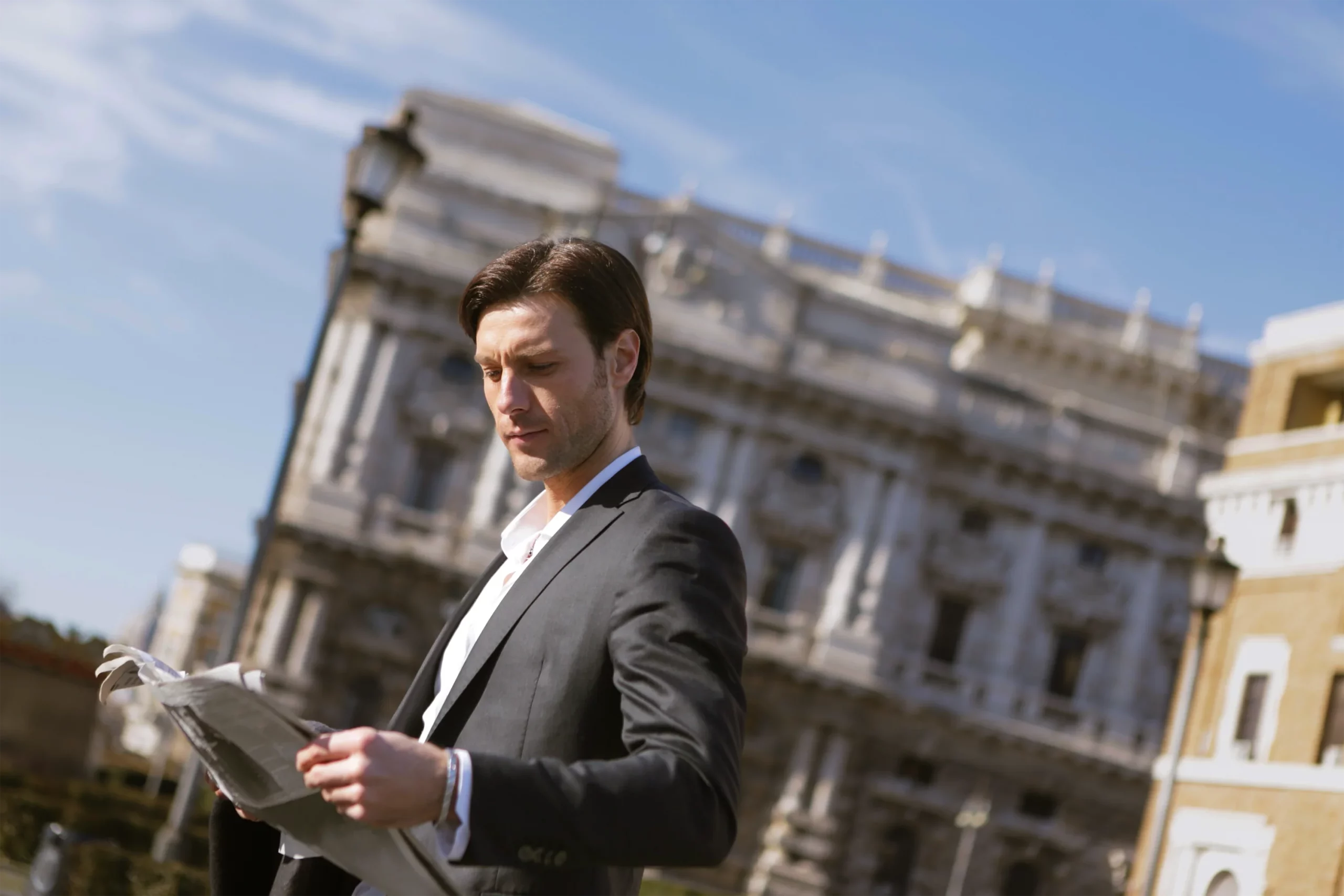 Un homme consulte ses documents de travail dans la rue.